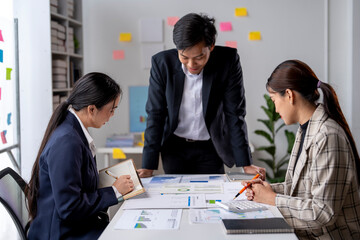 Three people are sitting at a table with papers and a book