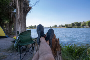 Enjoying the lake view in a camping chair. having a good time in nature. relaxing