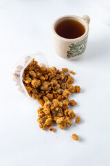 a small box of traditional peanut snack is spilled neatly and a cup of tea next to it