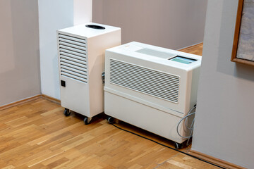 A modern industrial dehumidifier and an air purifier machine inside a museum, exhibition hall...