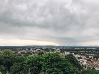 A city skyline is visible in the distance, with a cloudy sky overhead