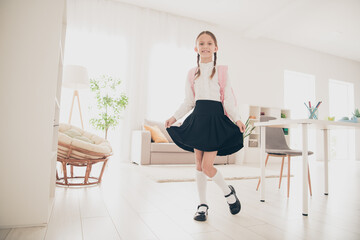 Full size photo of cute small schoolkid wear uniform living room apartment indoors