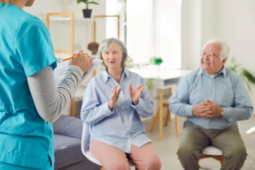 Fototapeta premium Female doctor, nurse, or caregiver talking with elderly, old patients during a meeting in the nursing home. Care, communication, and support for senior residents of retirement home.