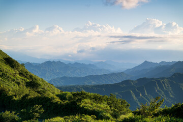 Enjoying the view of layered green mountains under a blue sky with white clouds. Captured in Jiufen, Taiwan.
