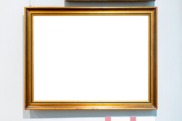 Plain simple middle size blank empty gold painting frame, hanging on a art museum gallery wall,...