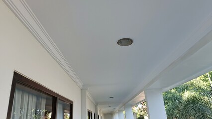 A white hallway with a white ceiling and a black trim