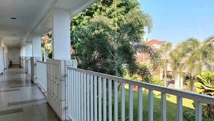 A white railing overlooks a lush green lawn