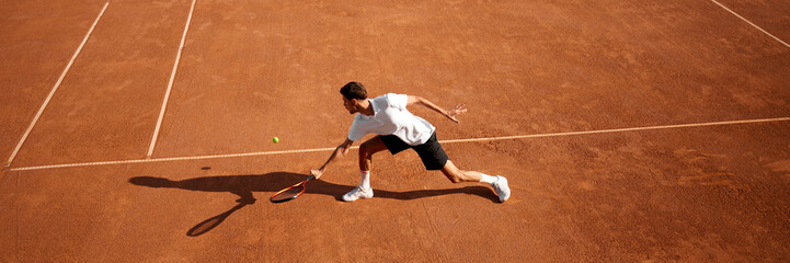 Motivated athlete, focused man, tennis player training hard on court, aiming for championship success. Banner. Concept of sport, competition, game event, active healthy lifestyle. Copy space for ad © master1305