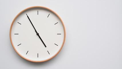 Minimalist wooden Wall Clock on White Wooden Surface with Space for Text – Time Set at 16.55/04.55