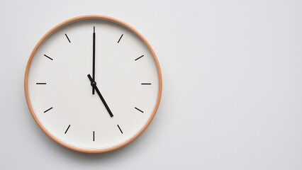 Minimalist wooden Wall Clock on White Wooden Surface with Space for Text – Time Set at 17.00/05.00