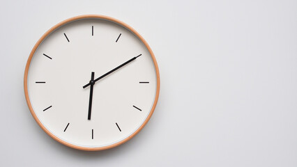 Minimalist wooden Wall Clock on White Wooden Surface with Space for Text – Time Set at 18.10/06.10