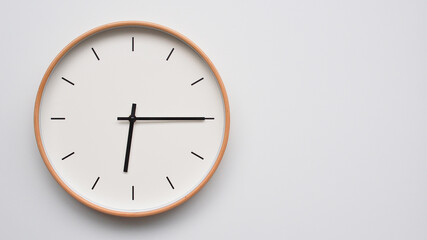 Minimalist wooden Wall Clock on White Wooden Surface with Space for Text – Time Set at 18.15/06.15