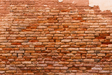 an old brick wall made of uneven, sometimes weathered and weathered bricks of varying shades from light beige to dark red. Brickwork creates a sense of history and time, conveying a warm and cozy atmo