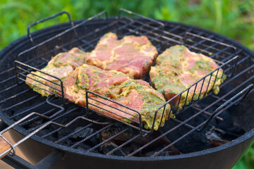 Backyard BBQ with Prepared Meat Ready for Grilling. Charcoal Kettle Grill Loaded with Seasoned Cuts in Wire Basket