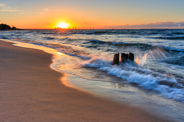 Obraz premium Sunset over the Baltic Sea beach in Gorki Zachodnie, Gdansk. Poland