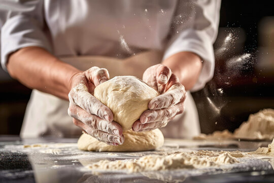 Person shaping dough with flour-covered hands.