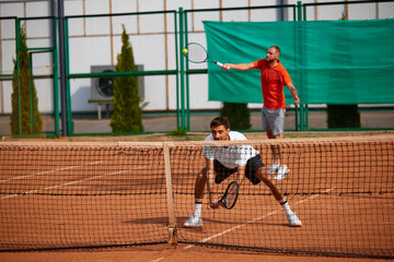 Two men showing focus and ambitions during intense match on outdoor clay court, growing skills and endurance for upcoming game. Concept of sport, competition, active and healthy lifestyle
