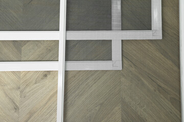 Fototapeta premium Set of window screens on wooden floor, flat lay