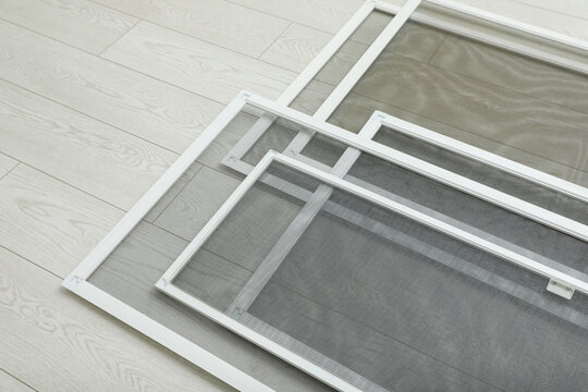 Set of window screens on wooden floor, above view