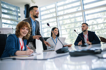 Man CEO talking on microphone on a meeting with his colleagues about business plan, future collaboration.