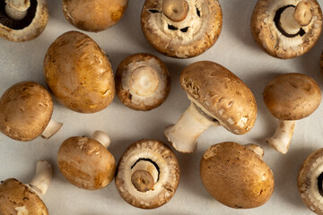 Raw champignons on bright background, button mushrooms. Vegan protein.