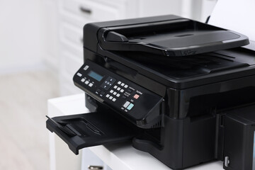 Modern printer with paper on table in office, closeup