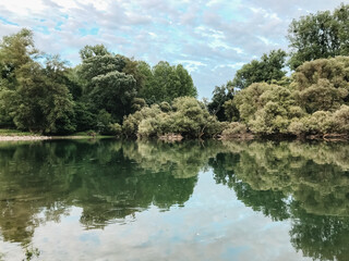 A calm lake with trees in the background