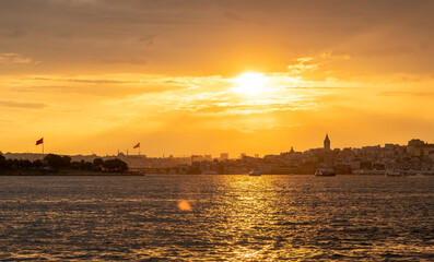 Golden rays of the sun illuminate the Bosphorus as the skyline of Istanbul subtl