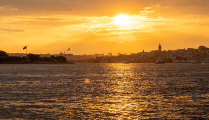 Naklejka premium The sun sets over the Bosphorus, casting a golden glow on Istanbul's skyline