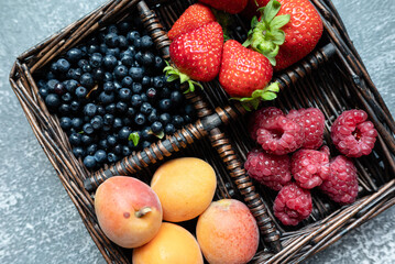 summer fruits in basket on dark background. close-up, place for text