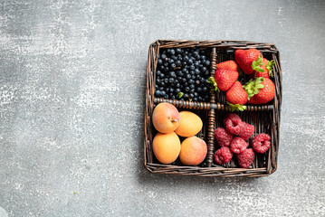 summer fruits in basket on dark background. close-up, place for text