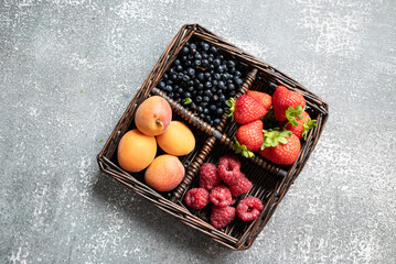 summer fruits in basket on dark background. close-up, place for text