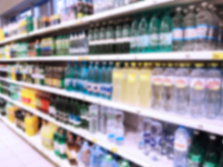 Abstract blur top supermarket is one of largest players of retail industry. Defocused shelves with products, bottles of water. Food. Mart. Aisle. Grocery store. Discount. Inflation concept. CPG.