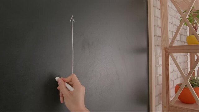 Close up of woman hand drawing coordinate axis with parabola on chalkboard, professor writes on blackboard or student solving task. Education and science concept.