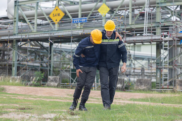 Oil refinery worker getting first aids help from his college after get injured while working on the site