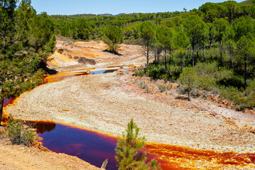 Rio Tinto river and iron mines. Red tinted river by copper, iron on the ground. Water used in life...