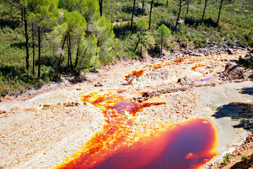 Rio Tinto river and iron mines. Red tinted river by copper, iron on the ground. Water used in life...