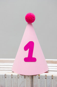 pink cardboard hat with pompom for birthday 1 year old