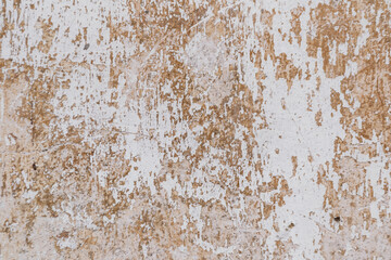 The wall is covered in peeling paint and has a rough texture