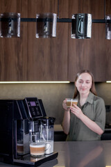 Female enjoying of fresh coffee aroma after brewing coffee using coffee maker in the kitchen at home.