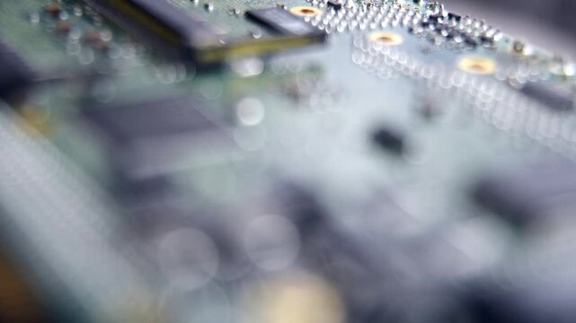 Close up view of electronic circuit board with microchips and components, moving focus gradually.