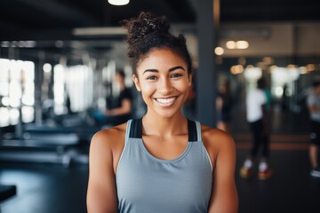 Fototapeta premium Portrait of a young female African American fitness trainer in gym