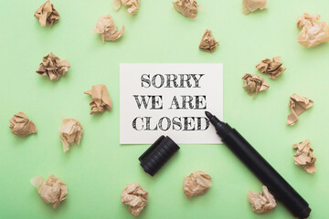 Sorry we are closed sign on a green background with a marker