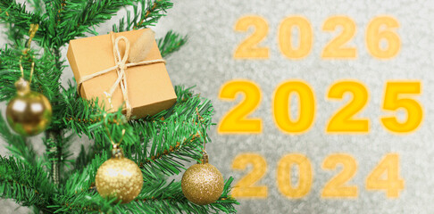 Happy New Year 2025 anniversary. Transition from 2024 to new year 2025 concept image with golden ball ornament on Christmas tree.