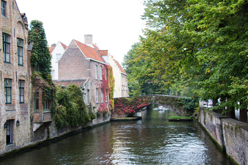 BRUGES, BELGIUM - SEPTEMBER 20, 2014: Beautiful canal in Bruges, surrounded by trees.