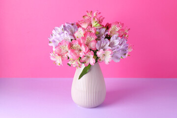 Beautiful alstroemeria flowers in vase on color background