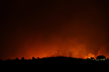Glow from a forest fire at night