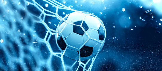 Soccer ball in goal net on blue background