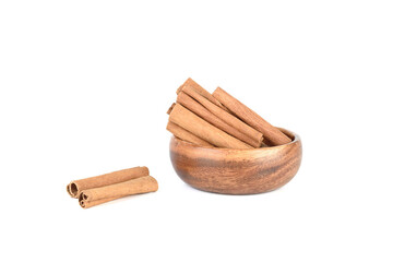 Dry cassia spice sticks in bowl and on white background.