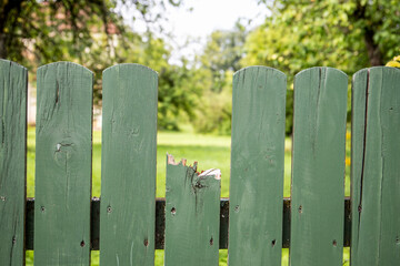 Broken and undamaged boards onf wooden fence, abstract concept of damage and failure